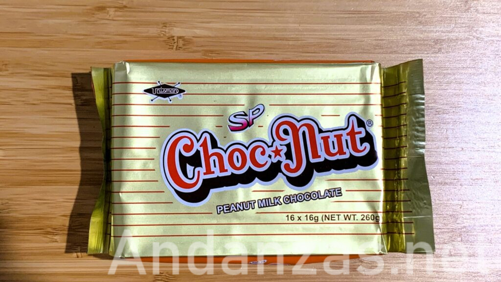 上から撮影したチョコナッツの金色のパッケージ。オレンジ色のボーダーと中央に赤い「Choco Nut」の文字が白く縁取られている