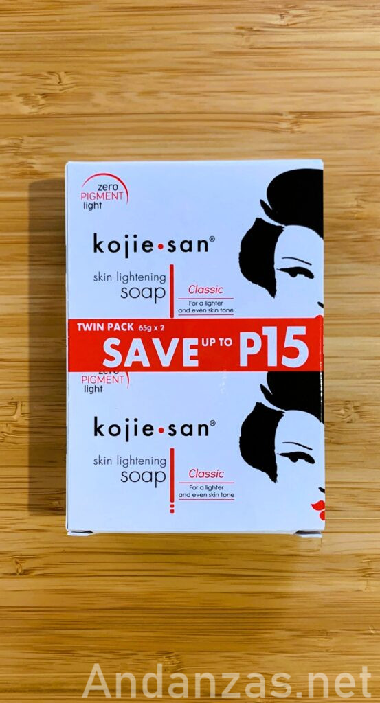 Koji・san石鹸の白い縦長パッケージ。中央には赤い帯があり、「SAVE P15」の白文字が目立つ。パッケージ右側には筆で描かれた日本人女性のイメージデザイン