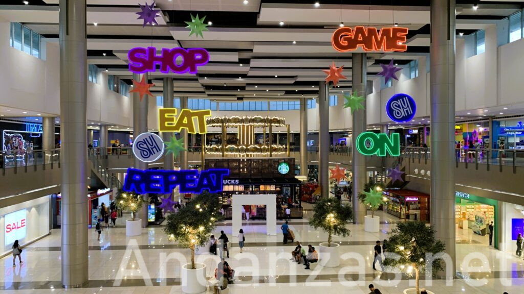 フィリピンSM City Clarkの広々とした館内。白を基調にした配色で、多くの店舗が並び、光る文字のデコレーションが印象的