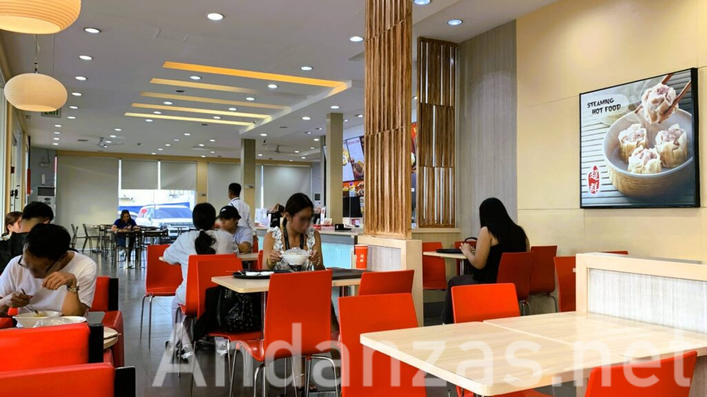フィリピン・アンヘレスのチョウキン店内。木製のテーブルと赤い椅子、白い天井、ベージュの壁が特徴的で、広く清潔で明るい雰囲気が感じられる。適度に客が入っている。