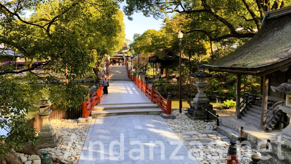 福岡・太宰府天満宮の心字池にかかる御神橋が見える風景。晴れた日の早朝、参拝客は少なく、境内には木々が目立つ静かな景色。