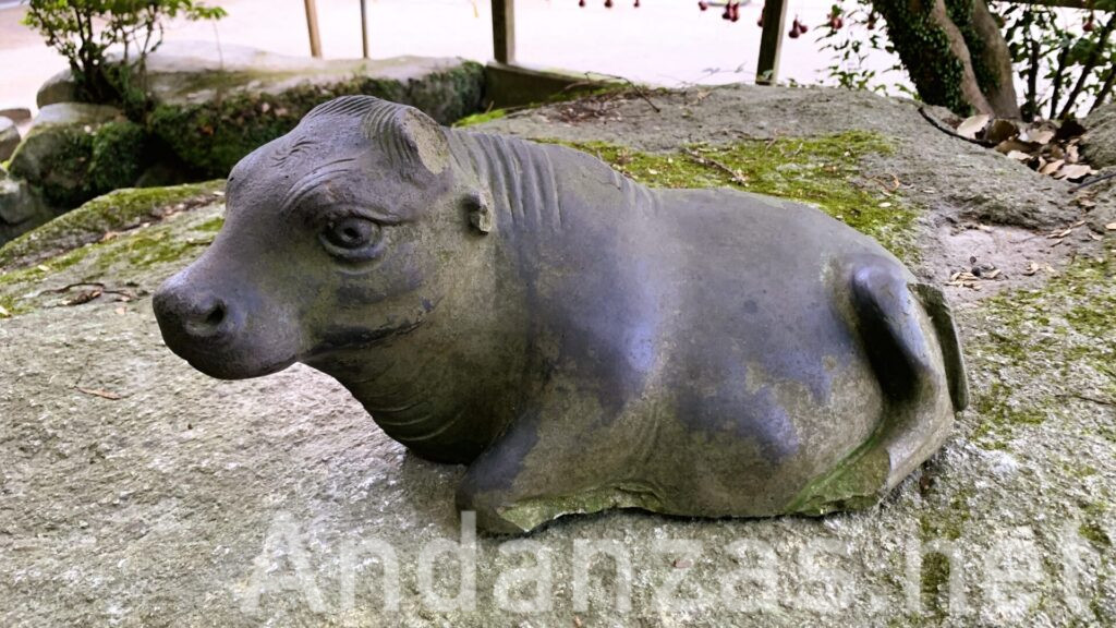 福岡・太宰府天満宮の岩の上に載っている御神牛。小さなサイズで黒い石が使われ、耳など一部が欠けているが、目が大きく優しい表情をしている。